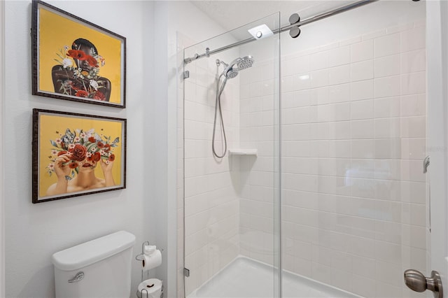 bathroom with tiled shower and toilet