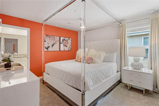 bedroom featuring carpet, a textured ceiling, and ensuite bath