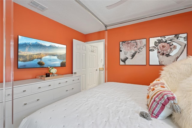 bedroom featuring ceiling fan and a textured ceiling