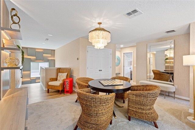 carpeted dining room featuring a textured ceiling and a notable chandelier