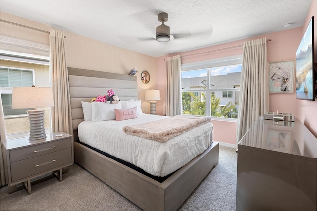 carpeted bedroom with a textured ceiling and ceiling fan