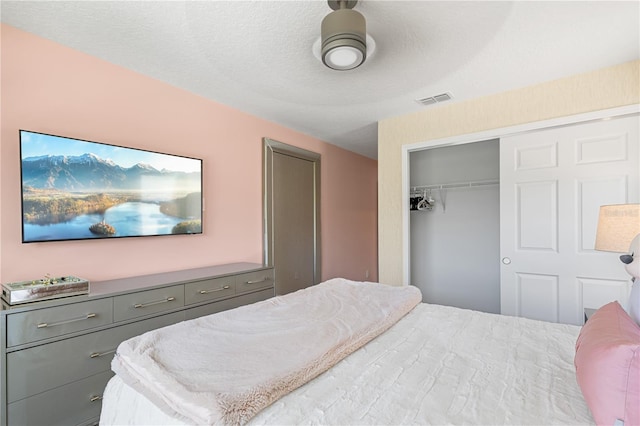 bedroom featuring ceiling fan, a closet, and a textured ceiling