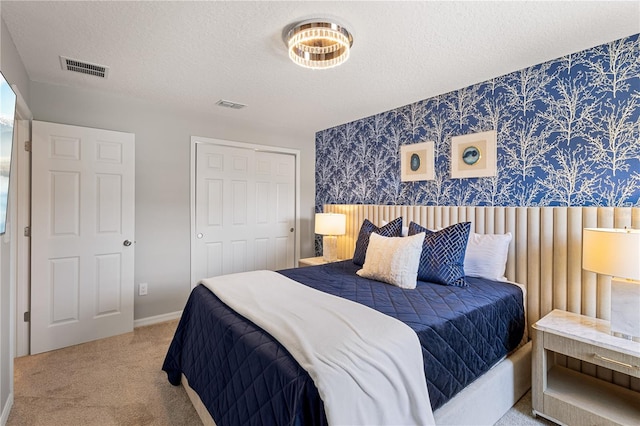 bedroom with a textured ceiling, a closet, and carpet flooring