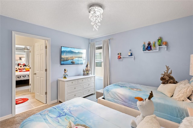 tiled bedroom with a notable chandelier and a textured ceiling