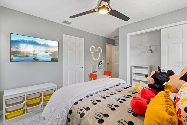 carpeted bedroom featuring ceiling fan and a closet