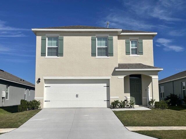 view of front of home with a front yard and a garage