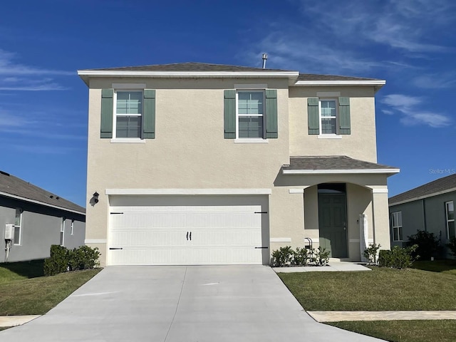 traditional-style home with an attached garage, a front yard, concrete driveway, and stucco siding