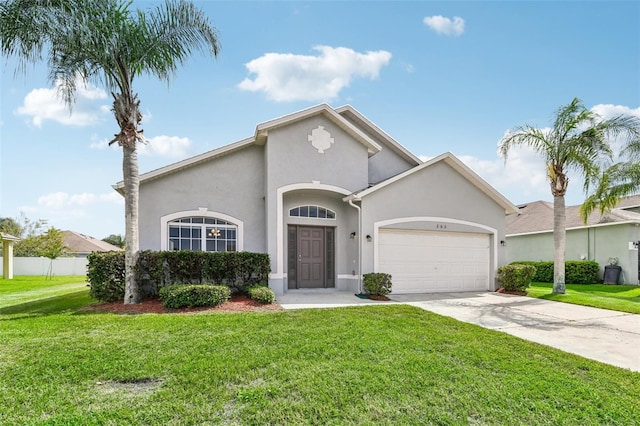 mediterranean / spanish home featuring a front yard, concrete driveway, an attached garage, and stucco siding