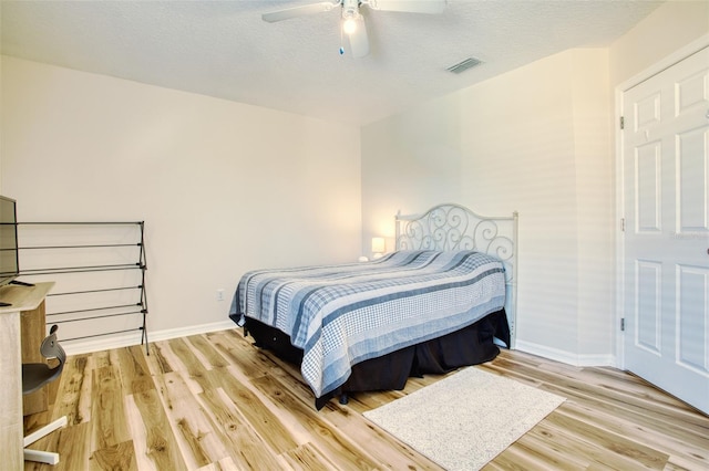 bedroom featuring a textured ceiling, light hardwood / wood-style flooring, and ceiling fan