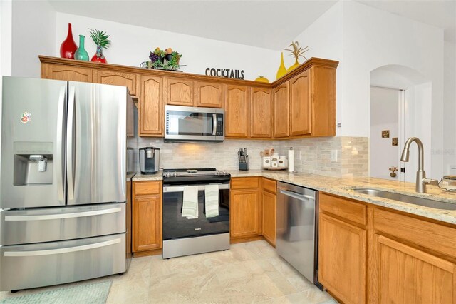 kitchen featuring sink, stainless steel appliances, decorative backsplash, and light tile patterned floors