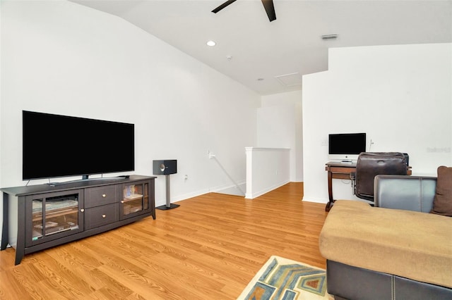 living room featuring ceiling fan, vaulted ceiling, and light hardwood / wood-style flooring