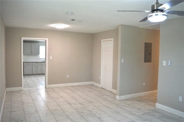 unfurnished room with ceiling fan and electric panel