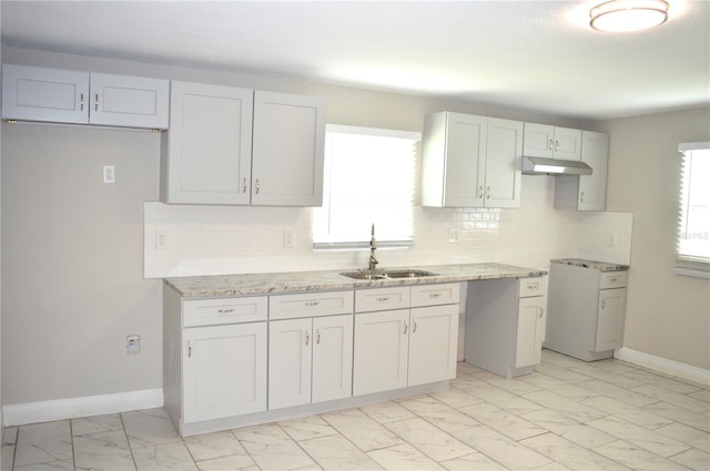 kitchen featuring decorative backsplash, sink, light stone counters, and white cabinets