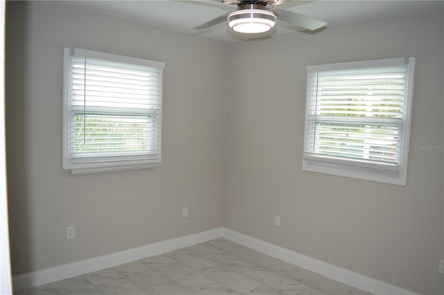 empty room featuring ceiling fan and plenty of natural light