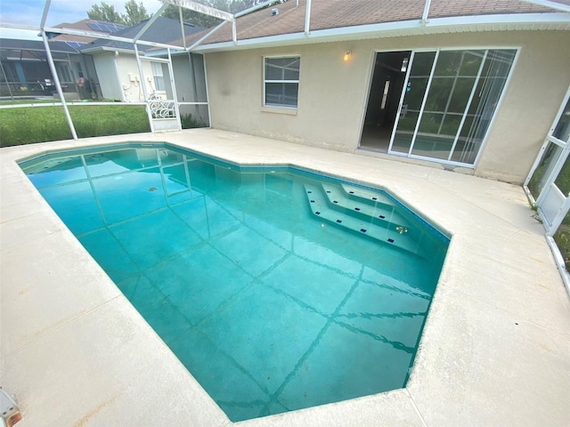 view of swimming pool featuring a lanai