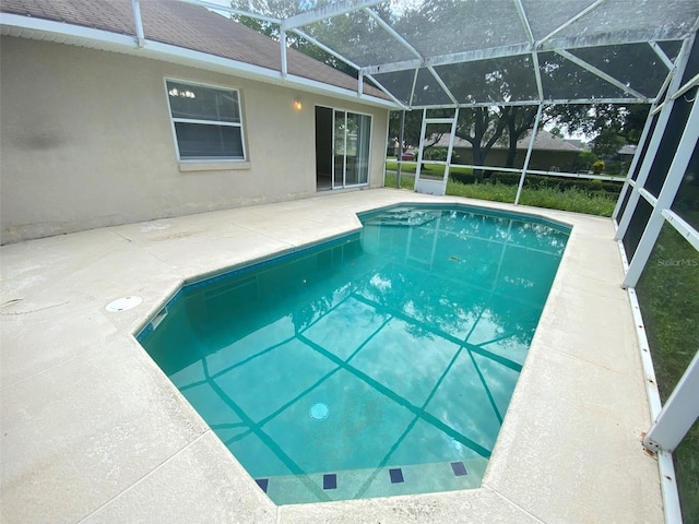 view of swimming pool with a patio area and a lanai