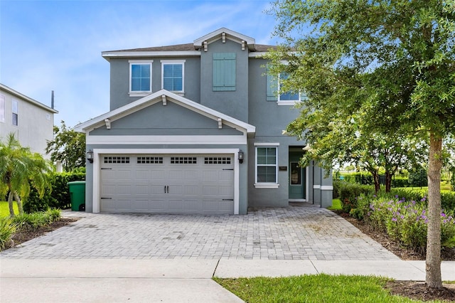 view of front of property with a garage, decorative driveway, and stucco siding