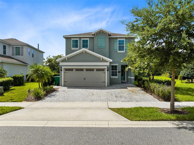 view of front facade featuring a garage, decorative driveway, and stucco siding