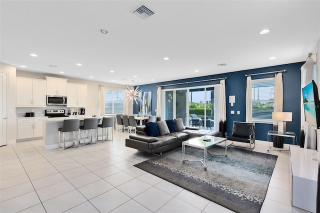 living room with light tile patterned floors, baseboards, visible vents, and recessed lighting