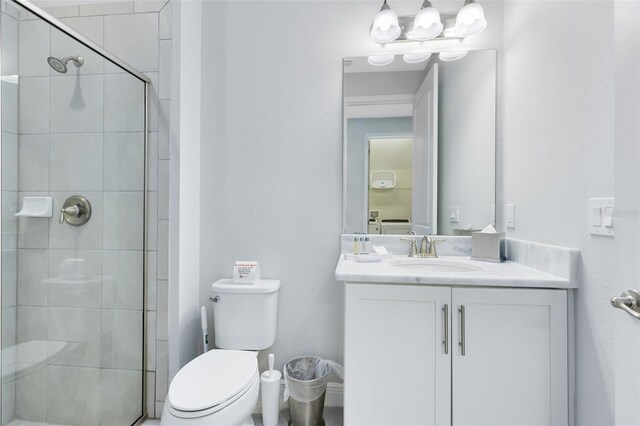 bathroom featuring a shower with door, toilet, vanity, and an inviting chandelier