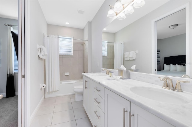 full bathroom featuring tiled shower / bath combo, toilet, double vanity, and tile patterned flooring