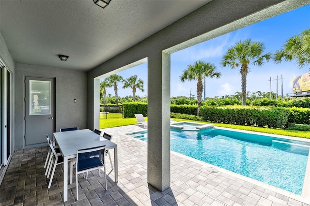 view of swimming pool with a patio, outdoor dining area, and a pool with connected hot tub