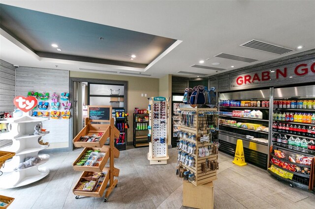 rec room with a raised ceiling and light tile patterned floors