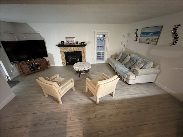 living area with a fireplace and baseboards