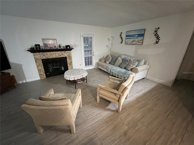 living area with wood tiled floor, a fireplace, and baseboards