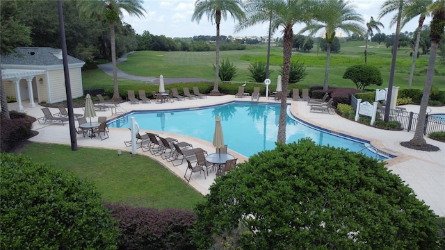 view of pool with a patio and a yard