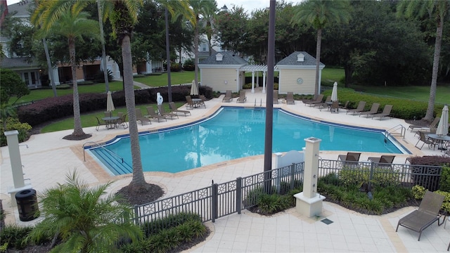 view of swimming pool featuring a patio area, central AC, an outdoor structure, and a lawn