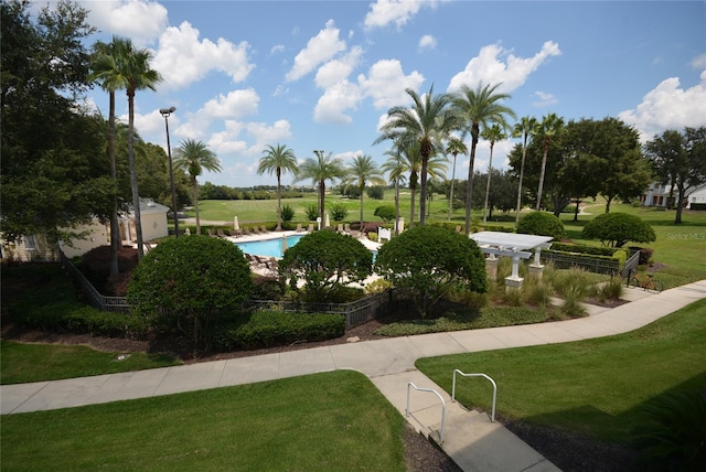 view of property's community with a yard and a pool