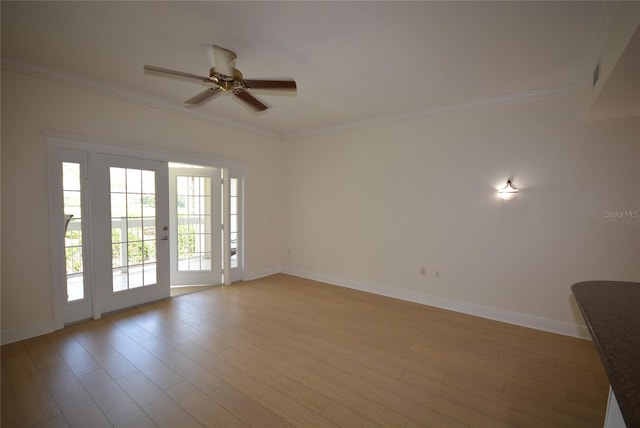 empty room with ceiling fan, crown molding, and wood-type flooring