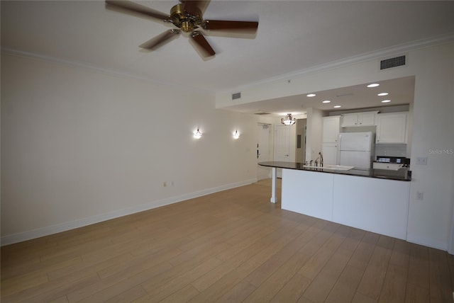 kitchen featuring light hardwood / wood-style floors, ceiling fan, white refrigerator, and white cabinets