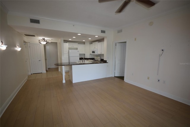 kitchen featuring sink, white appliances, white cabinets, and light wood-type flooring