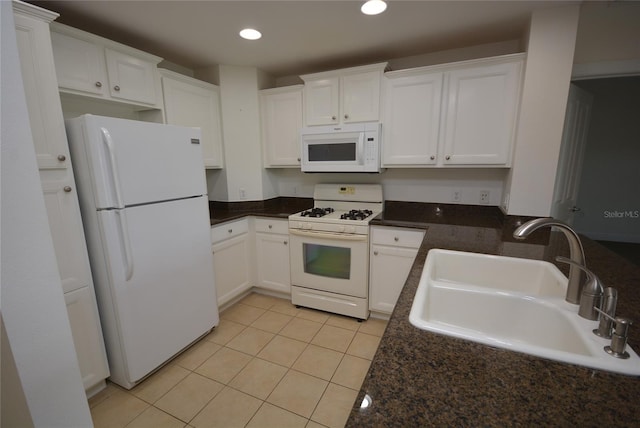 kitchen featuring sink, white appliances, light tile patterned flooring, and white cabinetry