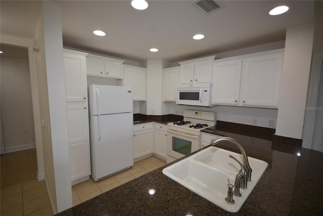 kitchen with sink, white cabinets, light tile patterned flooring, and white appliances