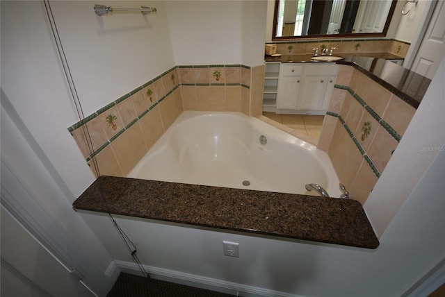 bathroom featuring tile patterned floors, a washtub, and vanity