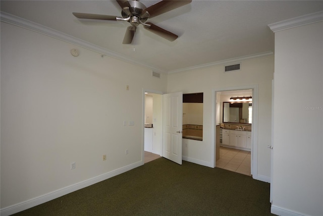 unfurnished bedroom featuring ceiling fan, connected bathroom, ornamental molding, and tile patterned floors