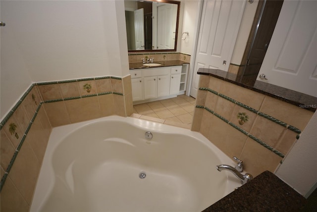 bathroom with tile patterned floors, a tub to relax in, and vanity