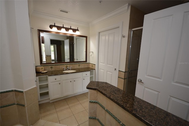 bathroom featuring tile patterned flooring, a shower with door, vanity, and ornamental molding