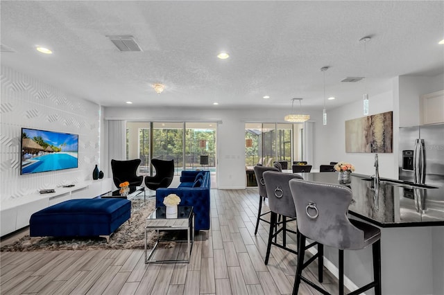 living room with light hardwood / wood-style floors and a textured ceiling