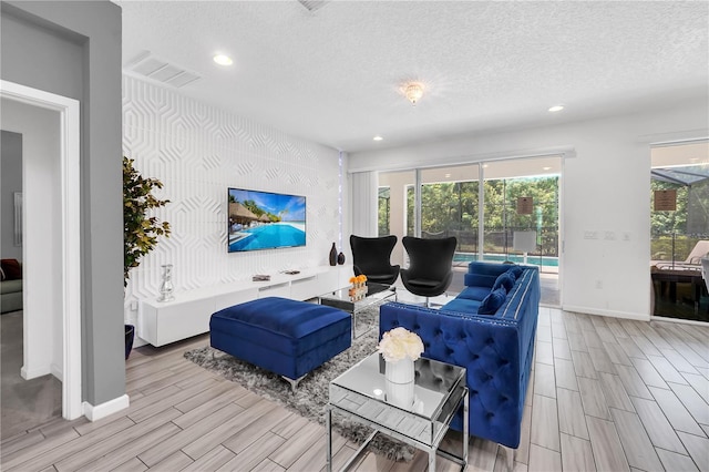 living room with light wood-type flooring and a textured ceiling