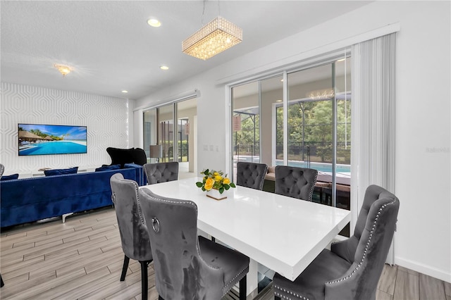 dining space with light hardwood / wood-style flooring and a chandelier