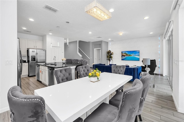 dining space with sink and light hardwood / wood-style floors