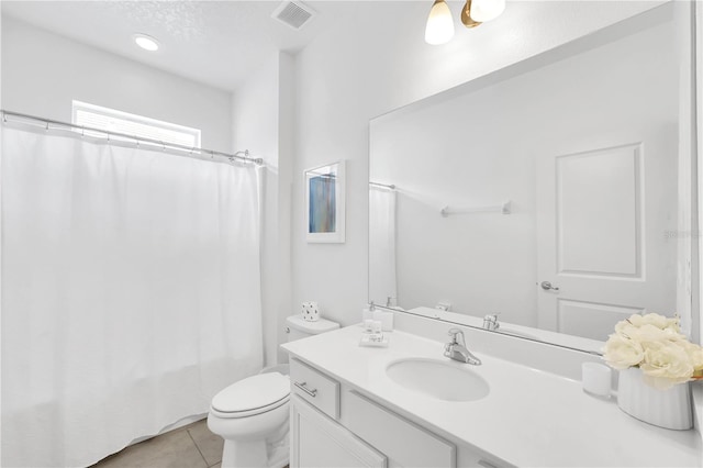 bathroom featuring tile patterned floors, toilet, a textured ceiling, and vanity