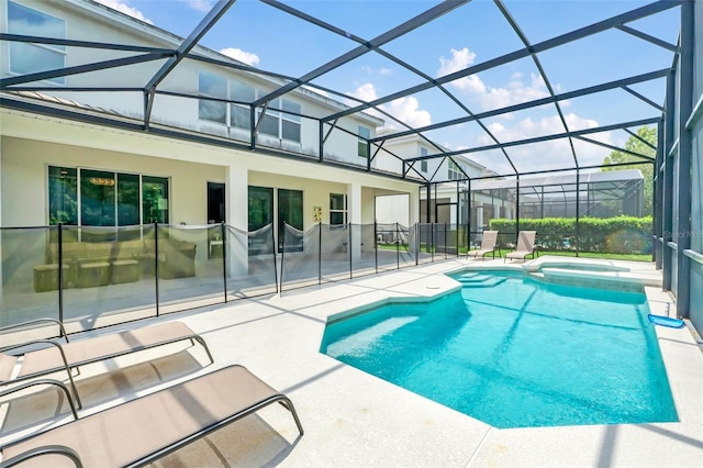 view of pool featuring glass enclosure, an in ground hot tub, and a patio area