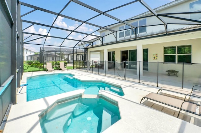 view of pool with an in ground hot tub, a patio area, and a lanai