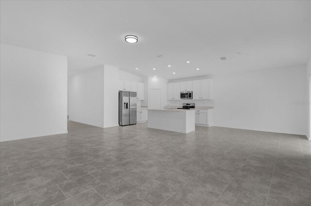 unfurnished living room featuring light tile patterned flooring and sink