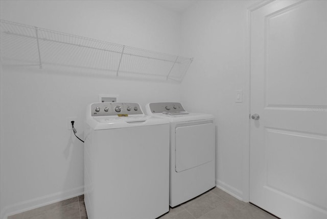 clothes washing area featuring light tile patterned floors and independent washer and dryer